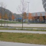 Stadtlandschaft mit der modernen Allianz Arena im Hintergrund und kahlen Bäumen, die auf Herbst oder Winter hinweisen. Fritten, Fussball & Bier - www.soccer-warriors.de