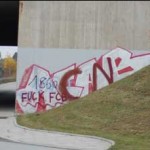 Graffiti am Straßenrand an einer Wand neben einem Halteverbotsschild und einer kurvenreichen Straße, in der Nähe der Allianz Arena. Fritten, Fussball & Bier - www.soccer-warriors.de